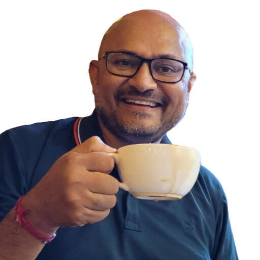 Ankit holding up a teacup with a blue polo shirt on