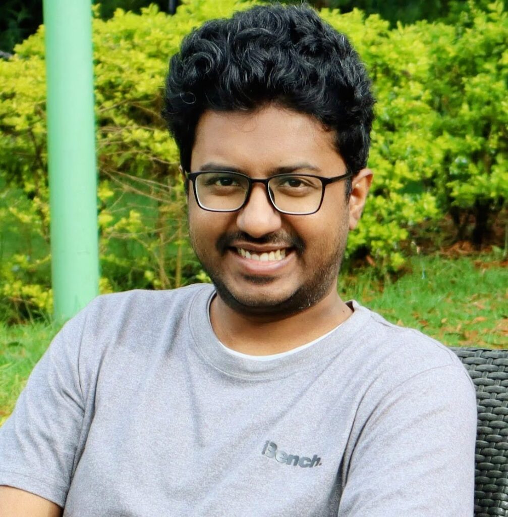 A picture of Ram wearing glasses and a grey t-shirt